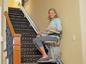 woman riding stairlift up stairs